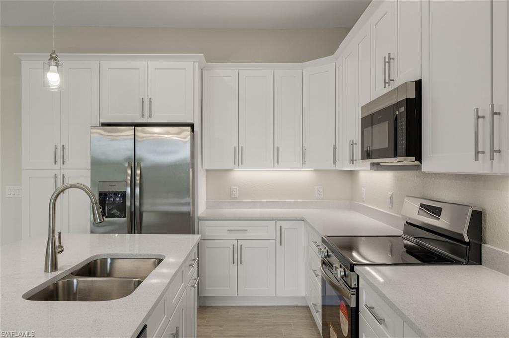 Gourmet kitchen with quartz island, shaker cabinets, and premium luxury vinyl plank (LVP) flooring upgrade.
