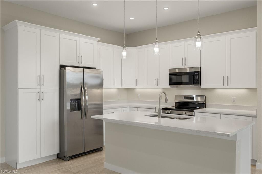 Gourmet kitchen with quartz island, shaker cabinets, and premium luxury vinyl plank (LVP) flooring upgrade.