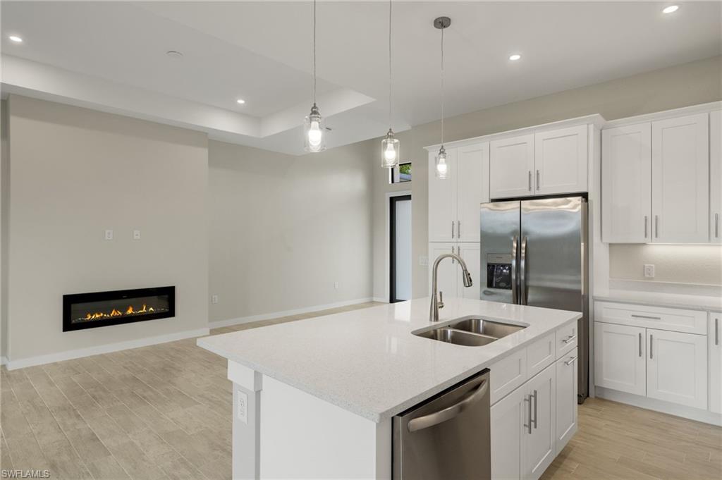 Gourmet kitchen with quartz island, shaker cabinets, and premium luxury vinyl plank (LVP) flooring upgrade.