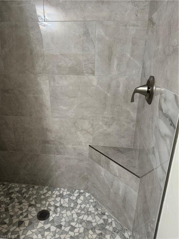 Walk in shower with seating and upgraded tiles.