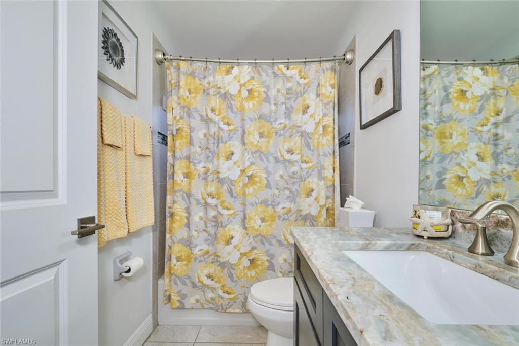 Bathroom featuring a built-in vanity with a stone countertop, an undermount sink, and a brushed nickel faucet