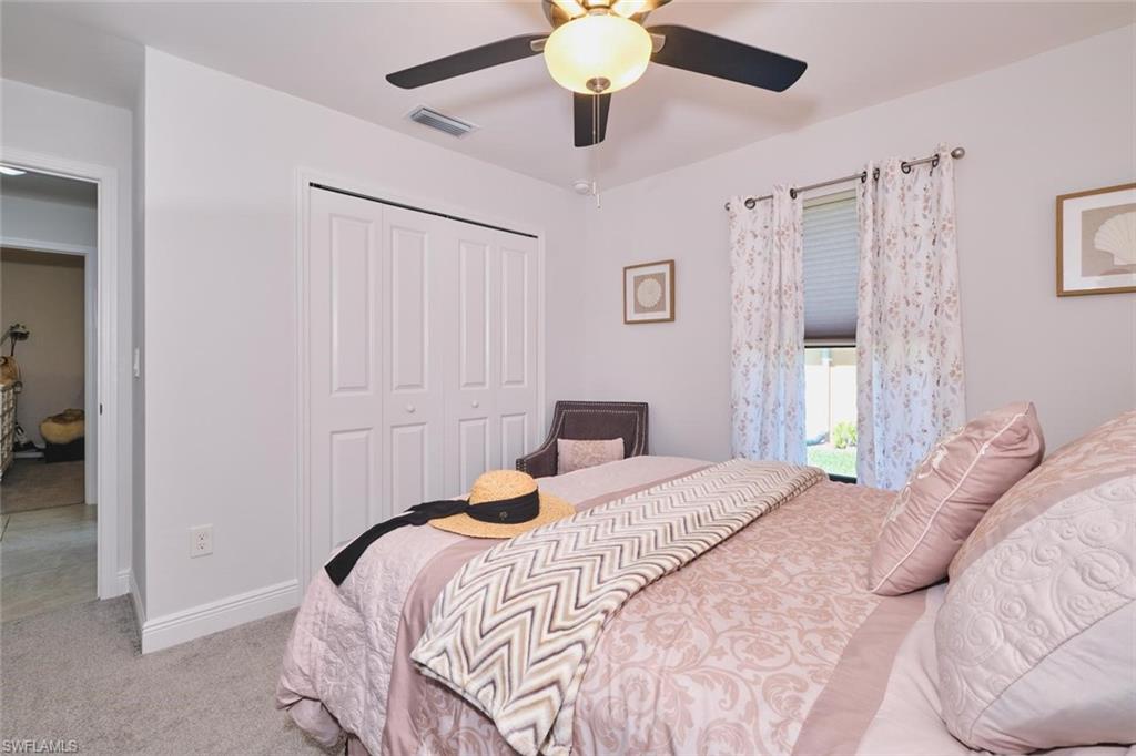BEDROOM 4  featuring light gray wall paint, carpeting, a ceiling fan with integrated lighting, and a window with blinds and decorative curtains