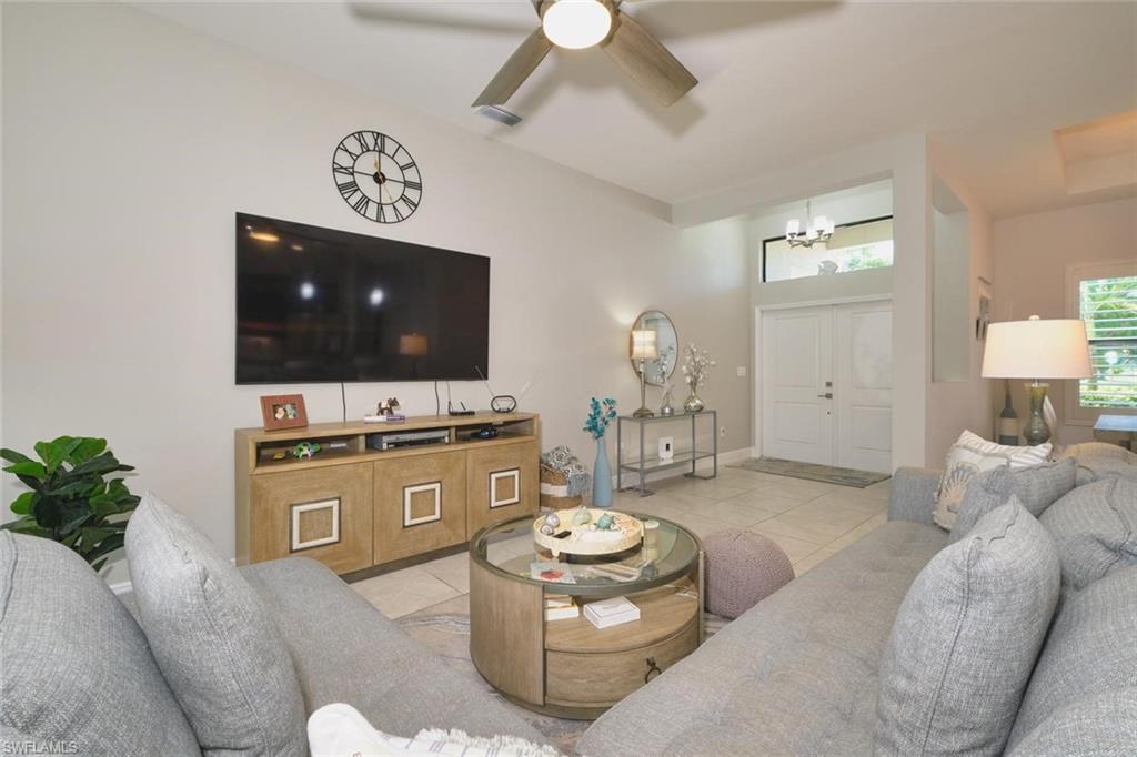 Living area featuring vaulted ceilings, a ceiling fan, and tile flooring