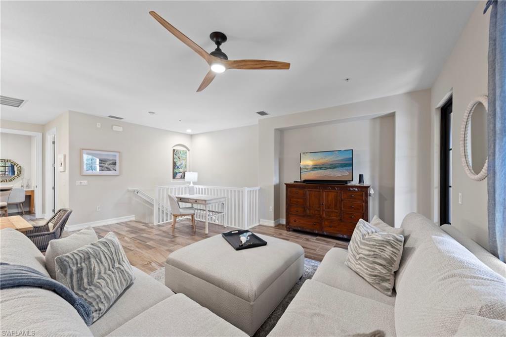 Open-concept living space featuring wood-finish flooring, a modern ceiling fan, and a built-in media niche. NEW TILE FLOOR (2018)