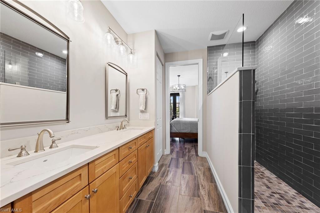 Double vanity with brushed nickel fixtures and quartz countertops. NEW QUARTZ COUNTERS (2018), NEW SHOWER REMODEL (2018), NEW MIRRORS (2018), NEW TILE FLOOR (2018)