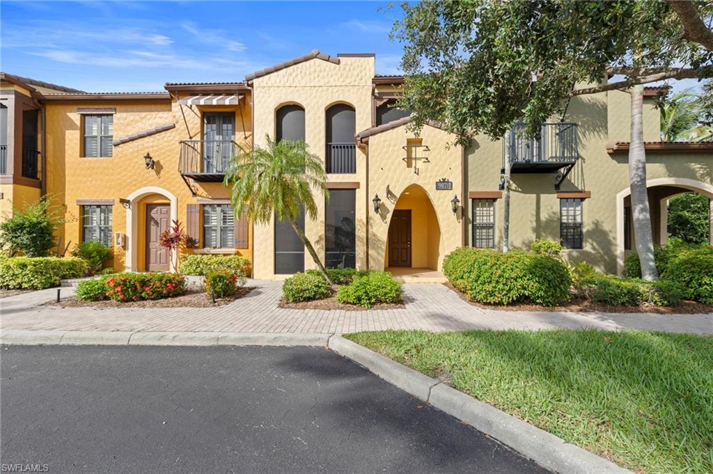 Mediterranean-style condos with stucco exterior, arched entryways, and decorative iron balconies. NEW FRONT DOOR TOUCH KEYPAD (2026), NEW NO-SEE-UM SCREEN LANAI (2025), NEW ROOF (2024), NEW AIR CONDITIONER (2021), NEW INTERIOR PAINT THROUGHOUT (2018)