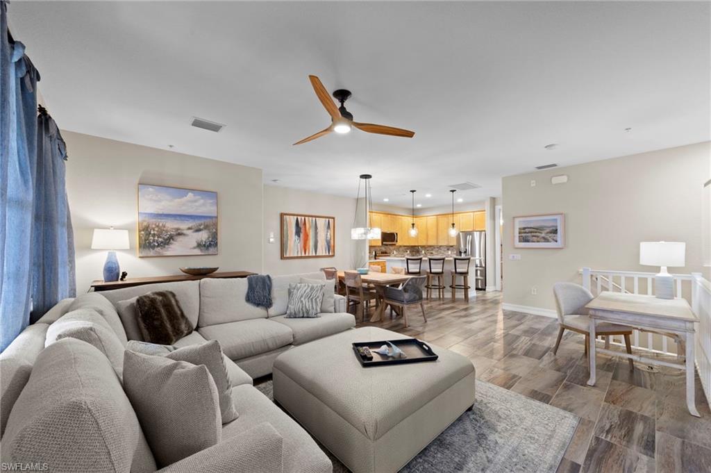 Spacious OPEN CONCEPT living area featuring TILE flooring, a contemporary ceiling fan, recessed lighting, and neutral wall tones. NEW TILE FLOOR (2018)