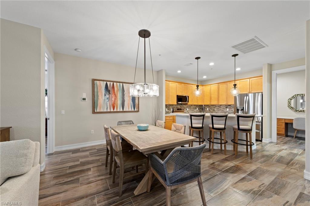 Open-concept dining and kitchen area featuring wood-finish tile flooring. NEW TILE FLOOR (2018)