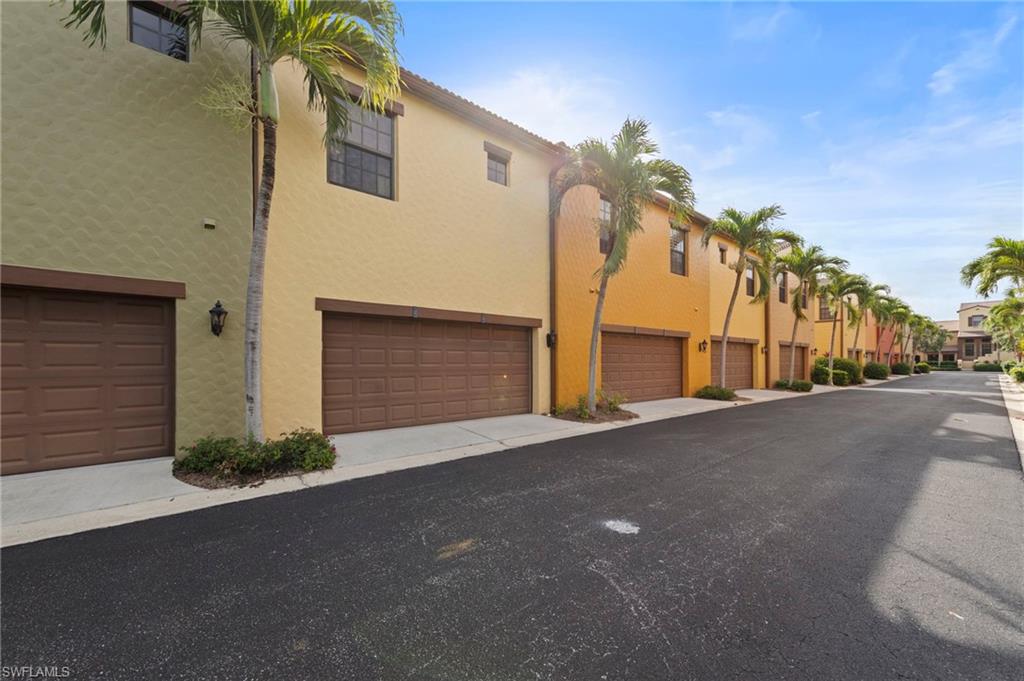 Row of multi-story condos featuring stucco exteriors and individual garage doors