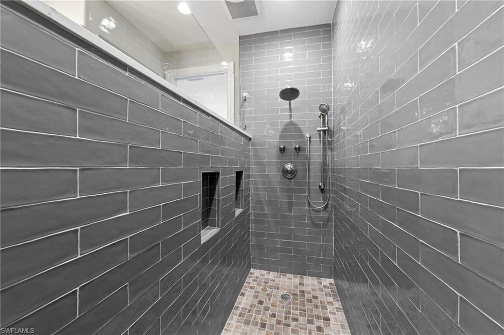 Walk-in shower featuring subway tile walls, a rain shower head, and a handheld shower fixture. NEW SHOWER REMODEL (2018)