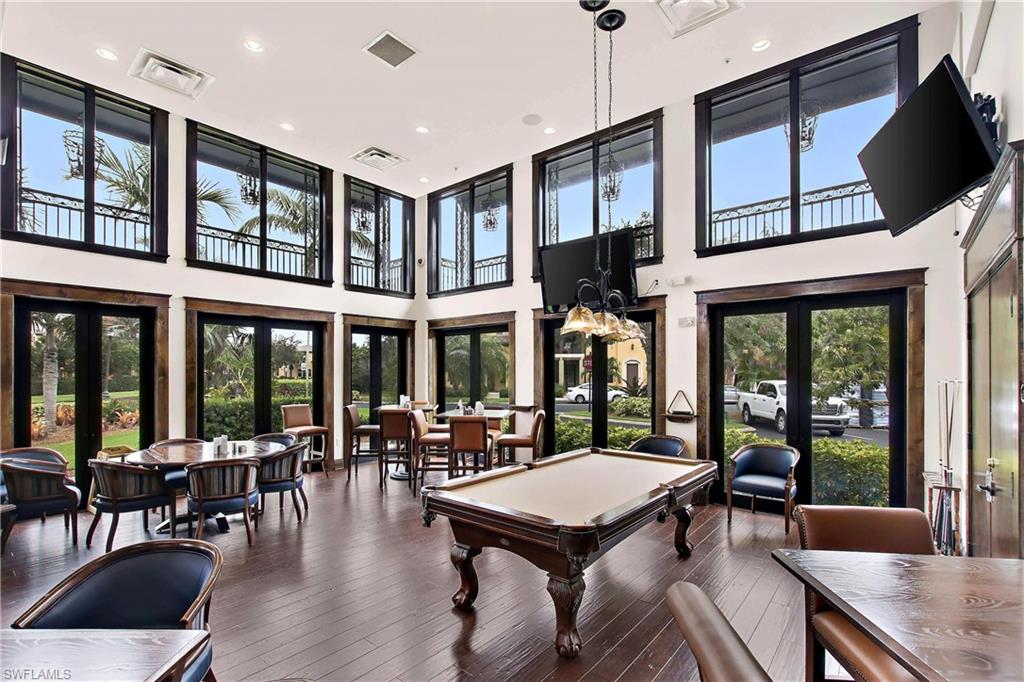 The Ole Pub features spacious gathering room with billiards table, wood flooring, high ceilings, and abundant natural light through multiple windows and glass-paneled doors
