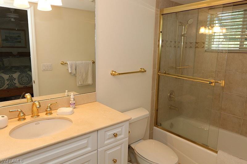 Bathroom with ensuite bathroom, enclosed tub / shower combo, vanity, and a chandelier