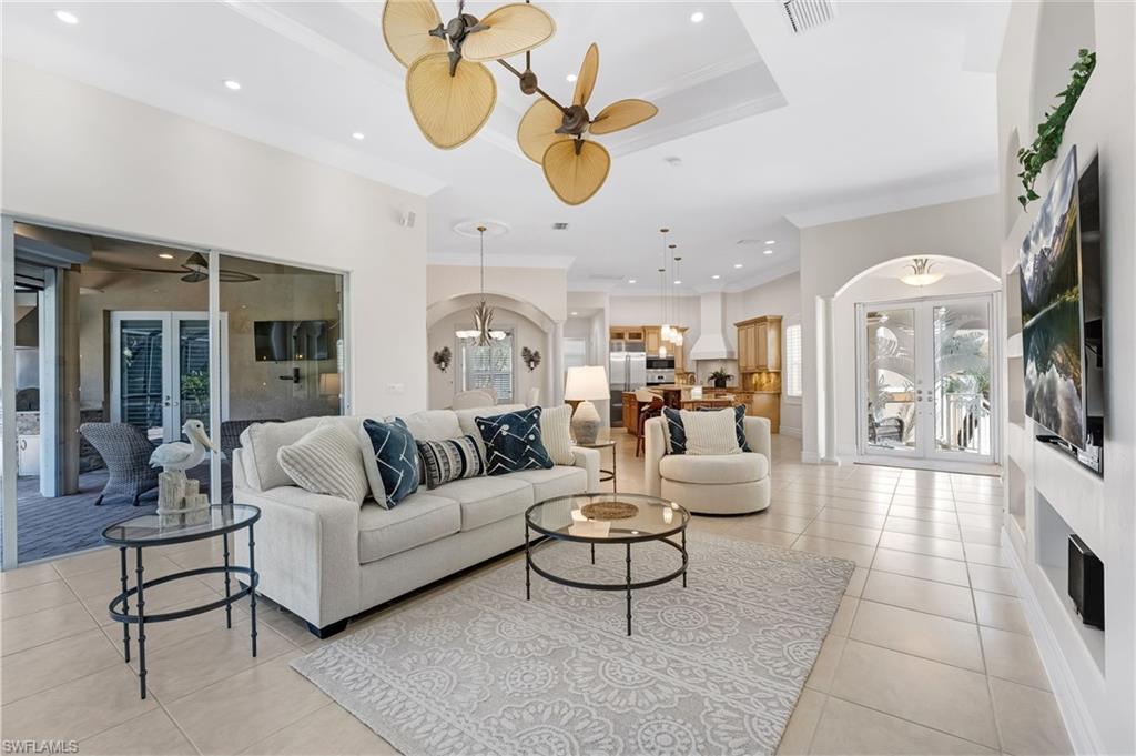 The main living area is elegantly finished with beautiful porcelain tile flooring and enhanced by soaring tray ceilings that create a grand sense of volume and sophistication. Architectural archways lend a refined, modern aesthetic, while custom built-ins add both style and functional elegance, completing this impeccably designed space.