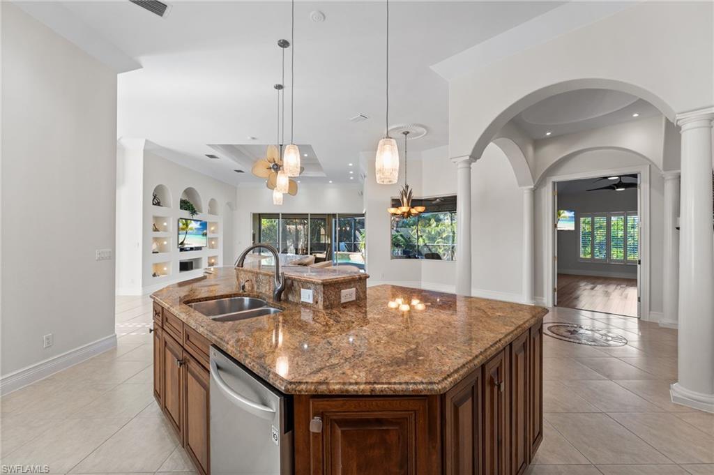 A custom-designed kitchen showcases 42-inch wood cabinetry, a striking two-tiered island, and elegant granite countertops, blending timeless craftsmanship with refined functionality for both everyday living and elevated entertaining.