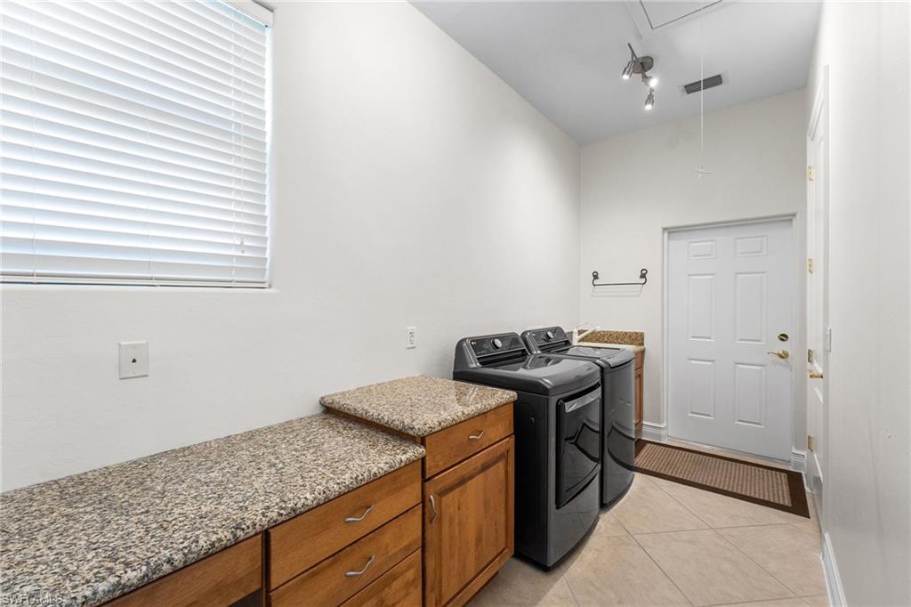 The oversized laundry room is thoughtfully designed with abundant storage and generous granite countertop space, combining everyday functionality with a refined sense of style and convenience.