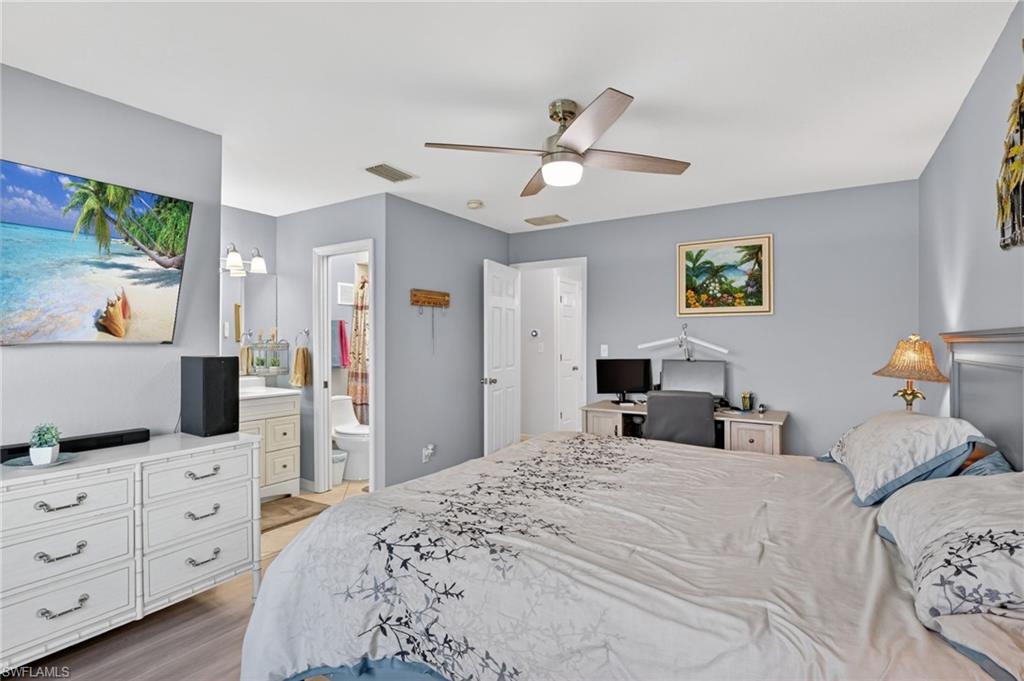 Bedroom featuring light gray walls, wood-finish flooring, and a ceiling fan with integrated lighting