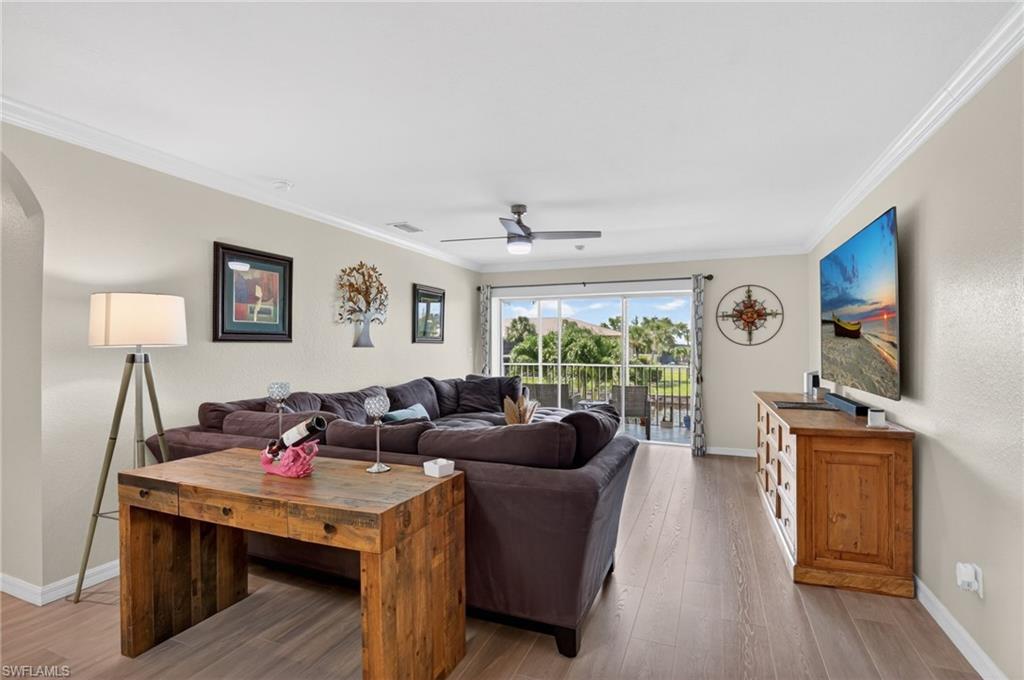 Spacious living area featuring wood-finish flooring and crown molding