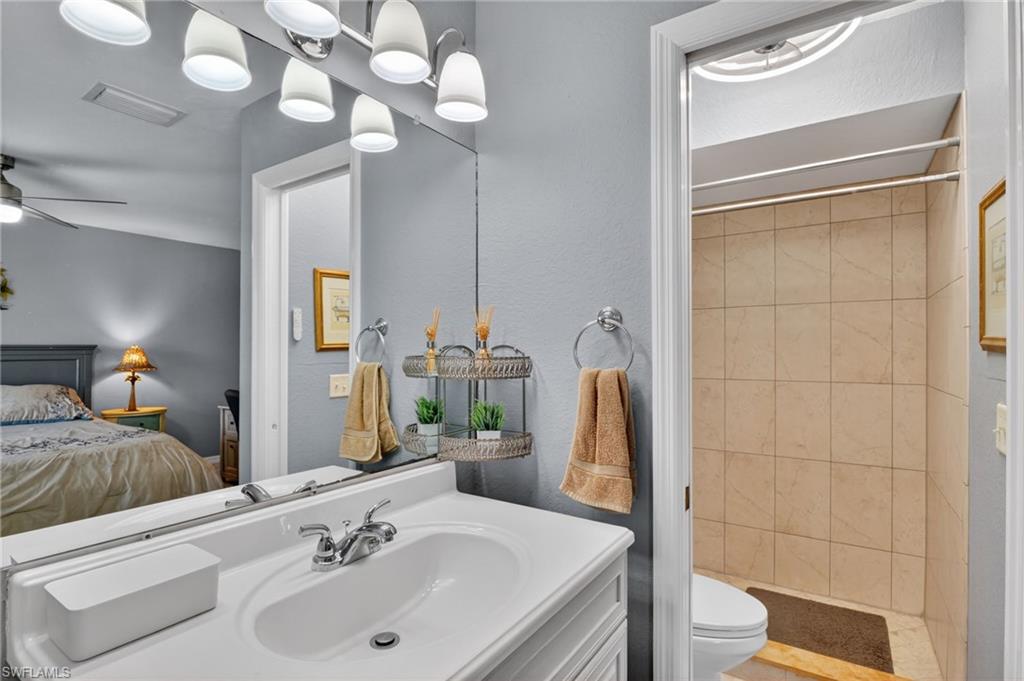 Bathroom vanity featuring a white countertop with integrated sink and chrome faucet