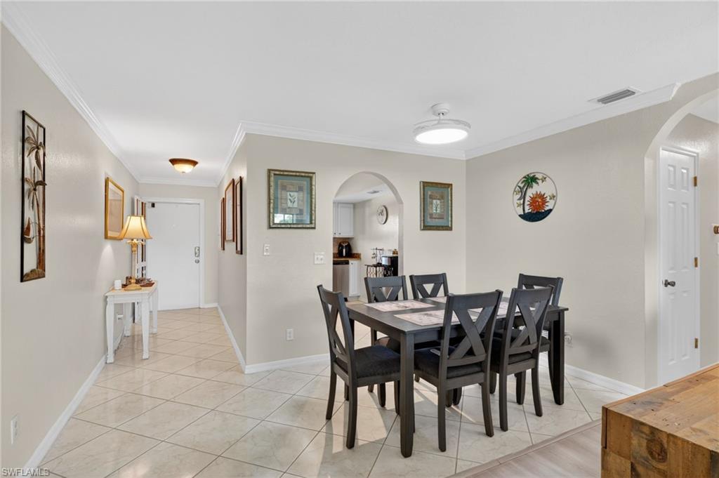 Dining area featuring crown molding, neutral wall tones, and tiled flooring