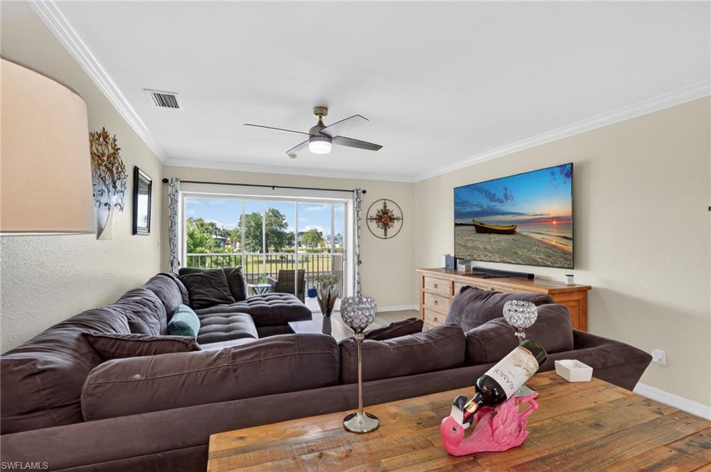 Living area featuring crown molding, a ceiling fan with integrated lighting, and neutral wall paint