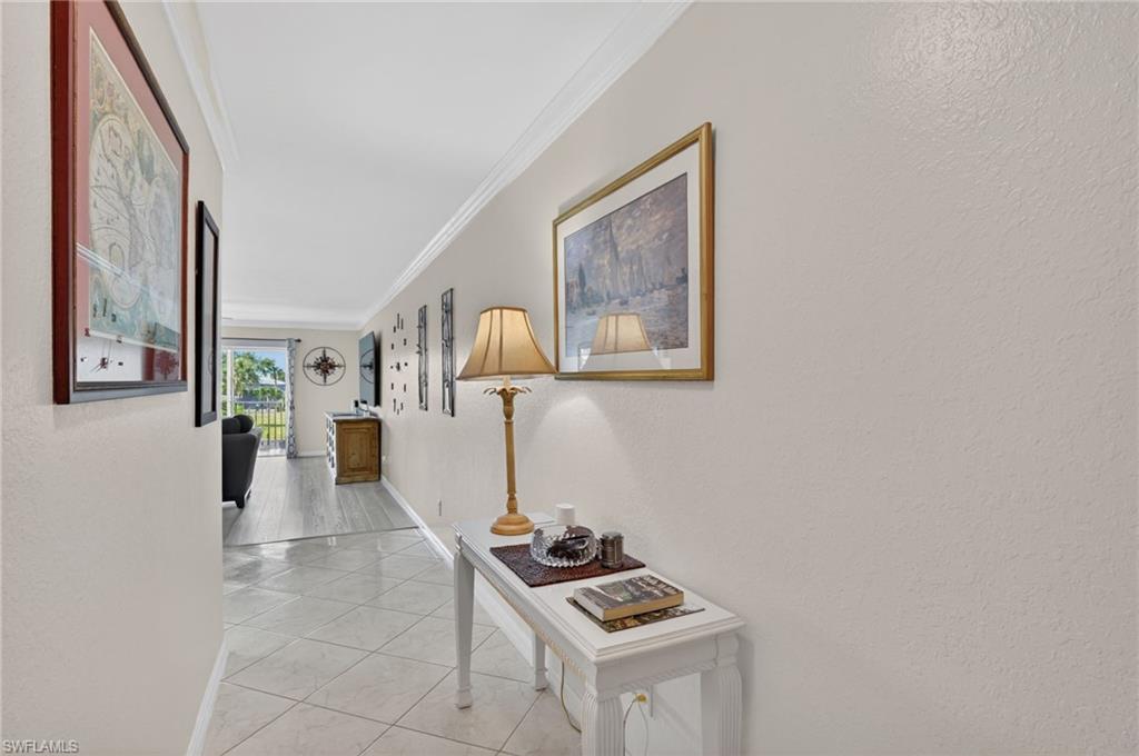 Hallway featuring crown molding and neutral wall tones