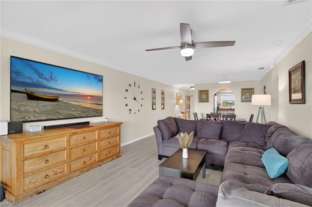 Spacious living area featuring light wood-finish flooring and crown molding