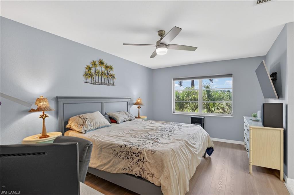 Spacious room featuring wood-finish flooring, a contemporary ceiling fan with integrated lighting, and a broad window