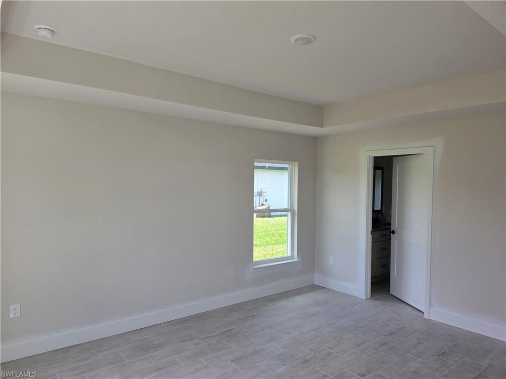 Recessed lighting, tray ceiling, tile flooring, interior window, and white trim accents
