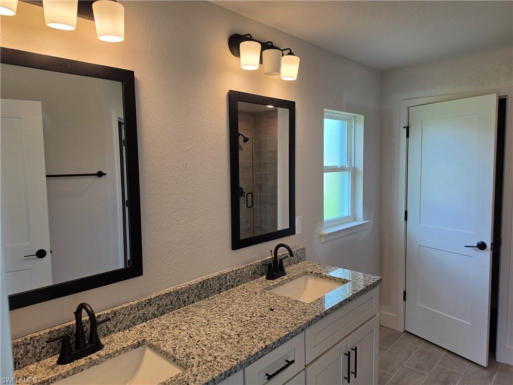 Dual vanity with granite countertops, undermount sinks, and matte black fixtures