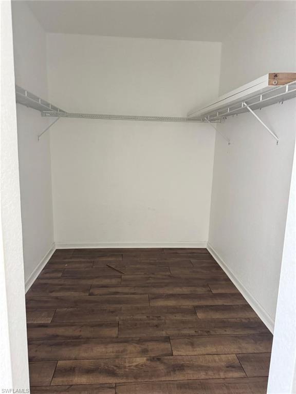 Spacious closet featuring wood-finish flooring, white walls, and a built-in wire shelving system