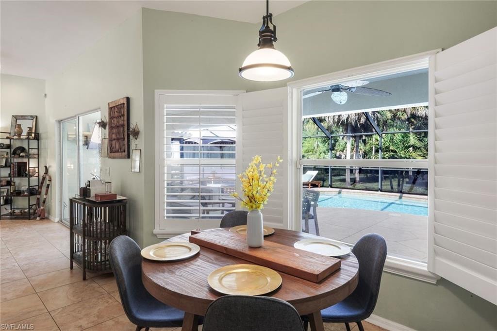 Dining area featuring a vaulted ceiling and tile flooring