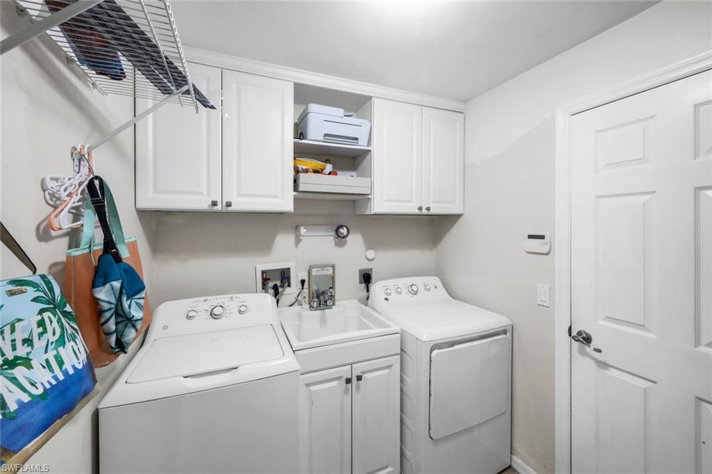 Dedicated laundry room featuring white cabinetry, a utility sink, and overhead wire shelving
