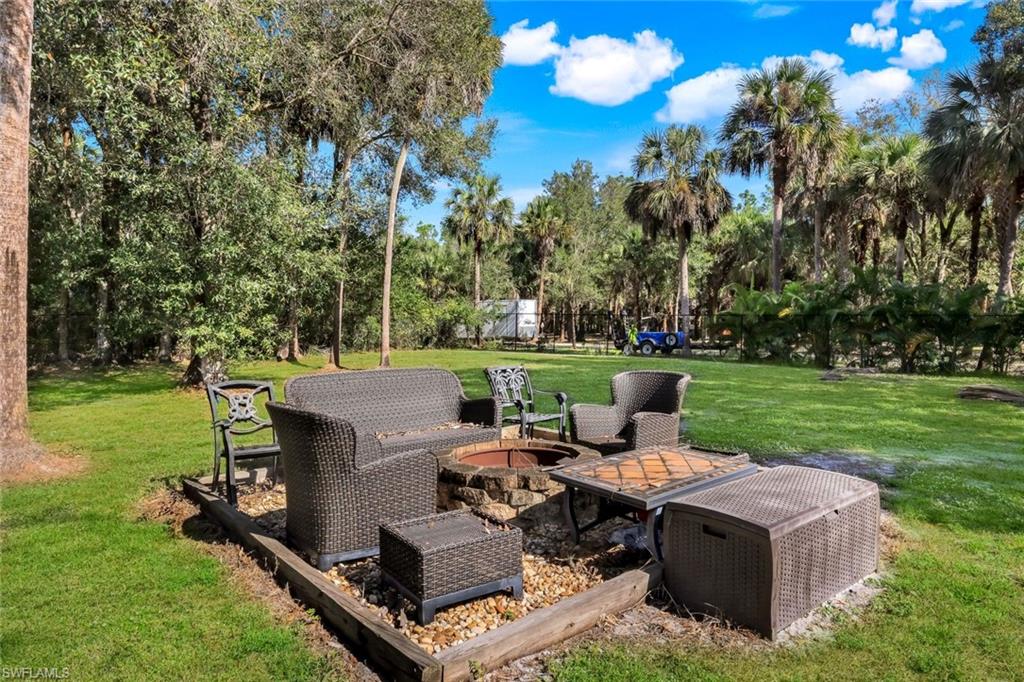 Fully fenced grass portion of yard, firepit area