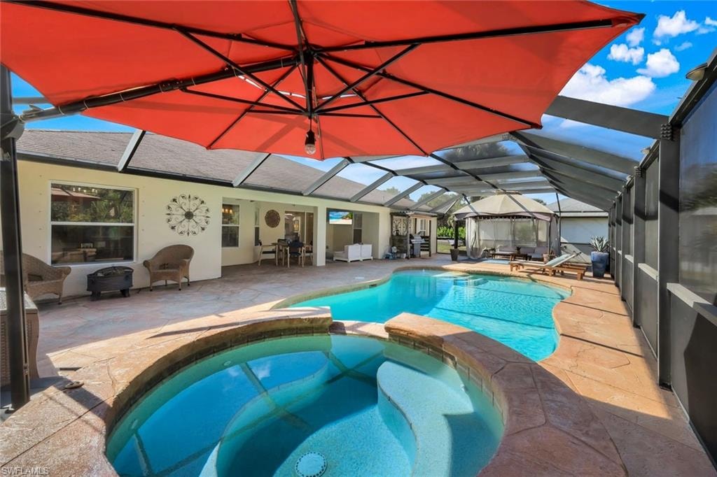 Screened outdoor living area almost 2k sq ft featuring a freeform swimming pool, integrated spa, and textured concrete decking