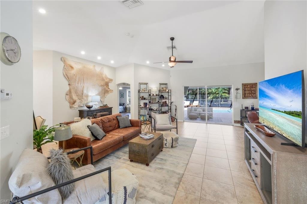 Expansive living area featuring vaulted ceilings, recessed lighting, and tile flooring