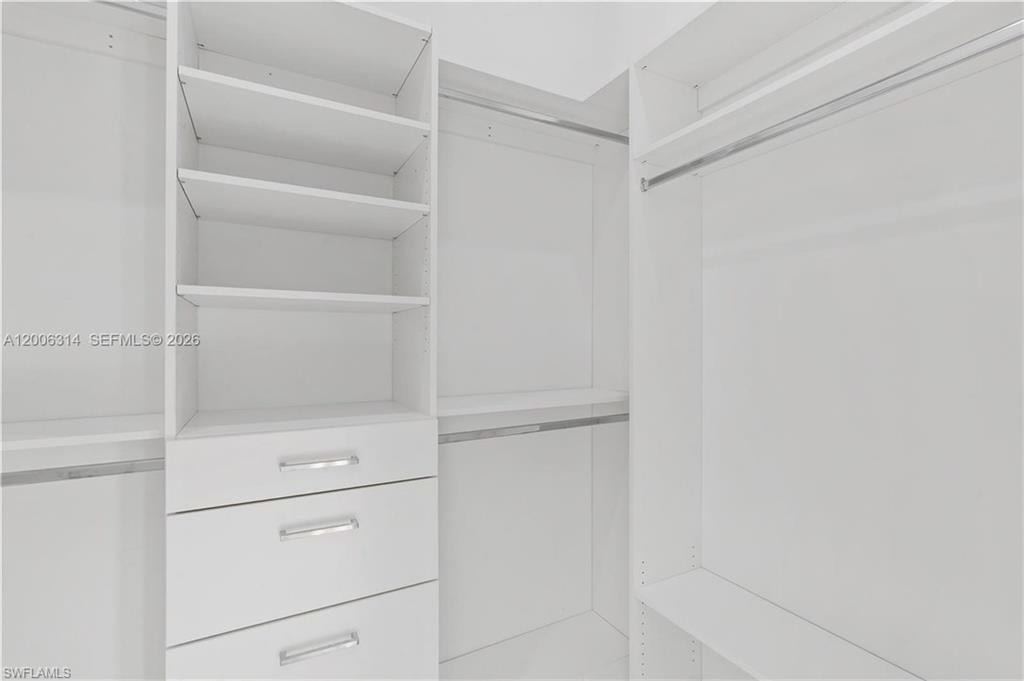 Custom closet system featuring white cabinetry