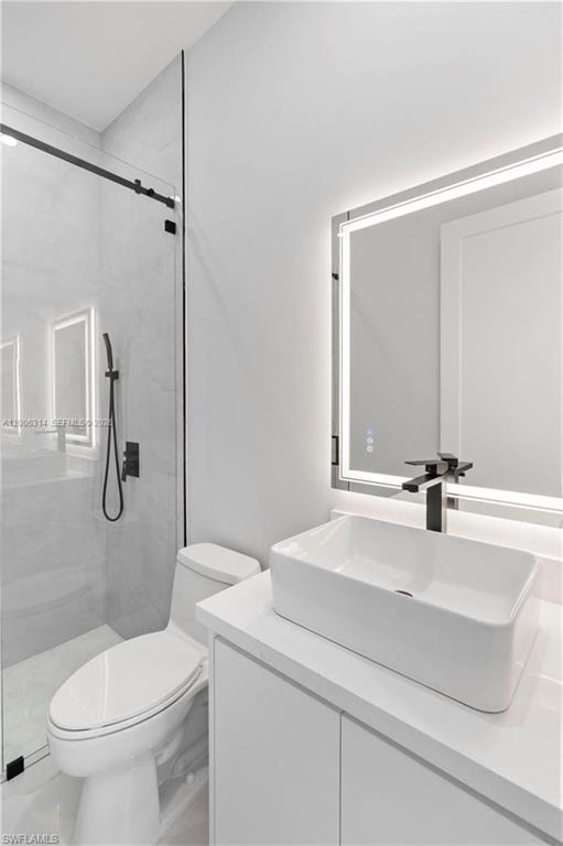 Modern bathroom featuring a rectangular vessel sink with a matte black faucet, a sleek white vanity with a solid surface countertop, and an illuminated mirror