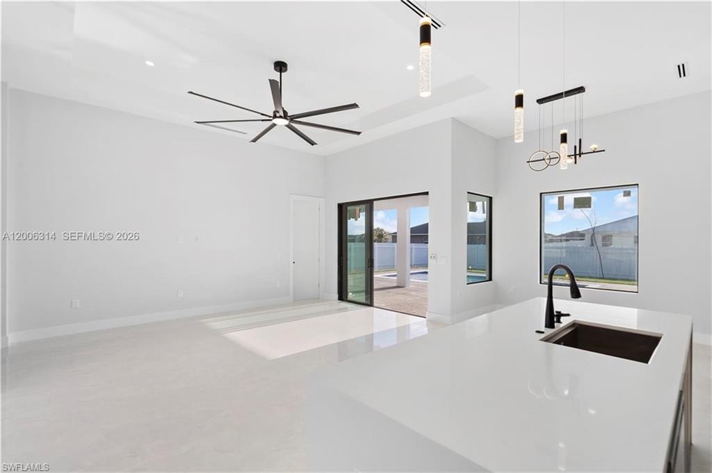 Spacious interior featuring high ceilings, contemporary ceiling fan, and large format tile flooring