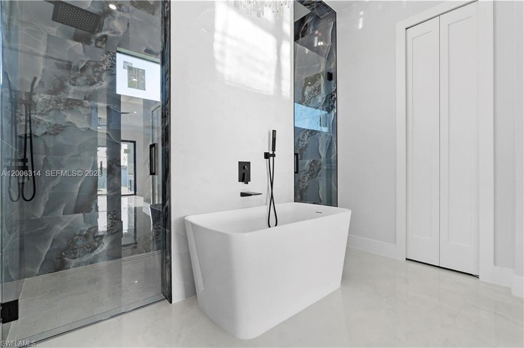 Modern freestanding soaking tub with matte black fixtures