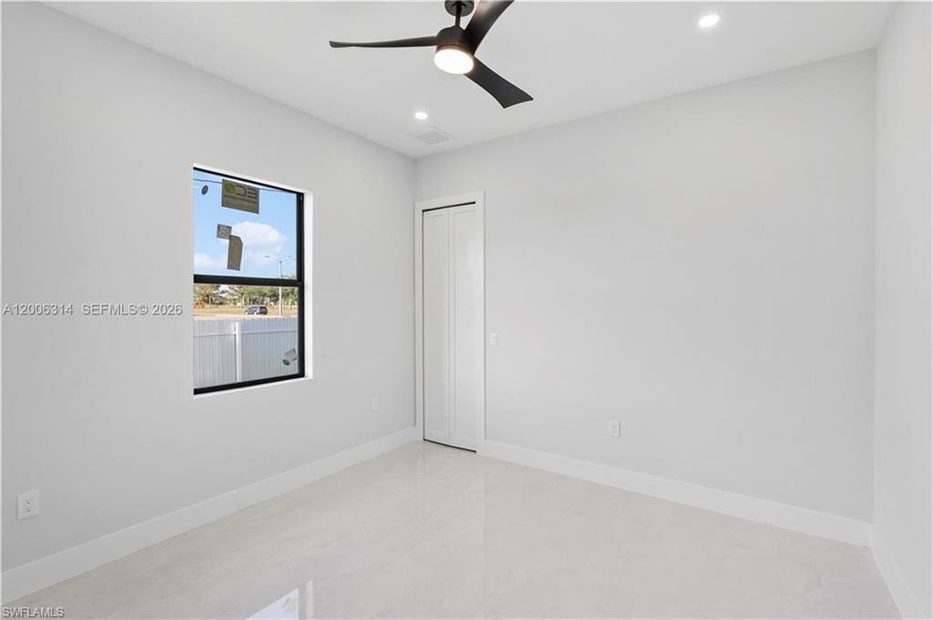 Bright room with a modern ceiling fan, recessed lighting, a single window, white baseboards, and light-colored tile flooring