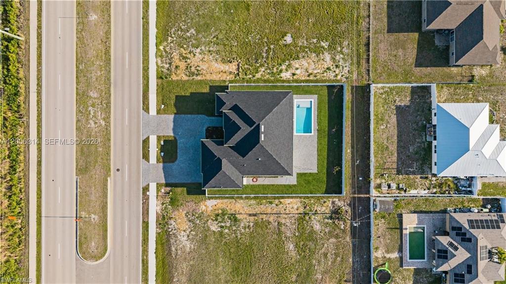 Modern residence featuring a dark shingle roof and an attached swimming pool