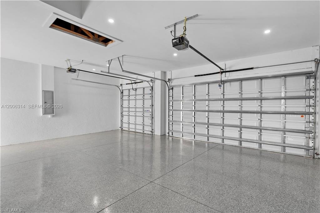 Two-car garage featuring a speckled epoxy floor and two overhead garage doors