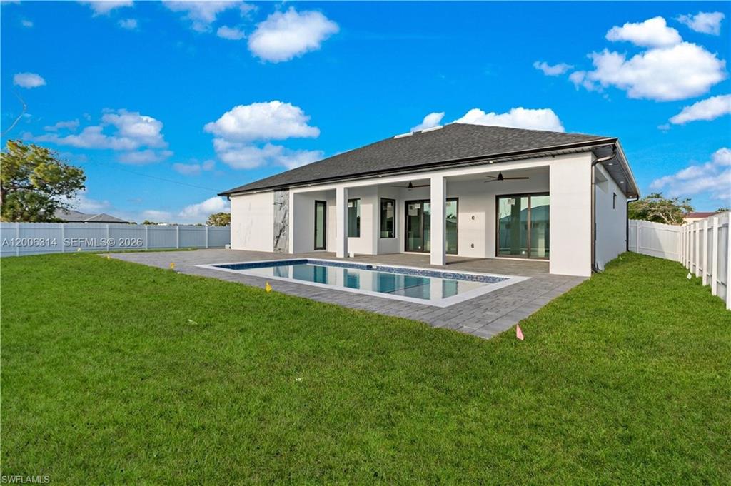 Contemporary white stucco exterior with a dark shingle roof and a private swimming pool