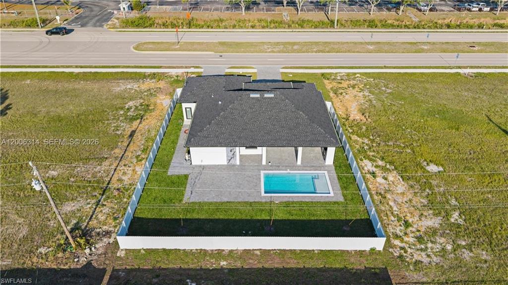 Contemporary single-story residence featuring a dark shingle roof and a private swimming pool