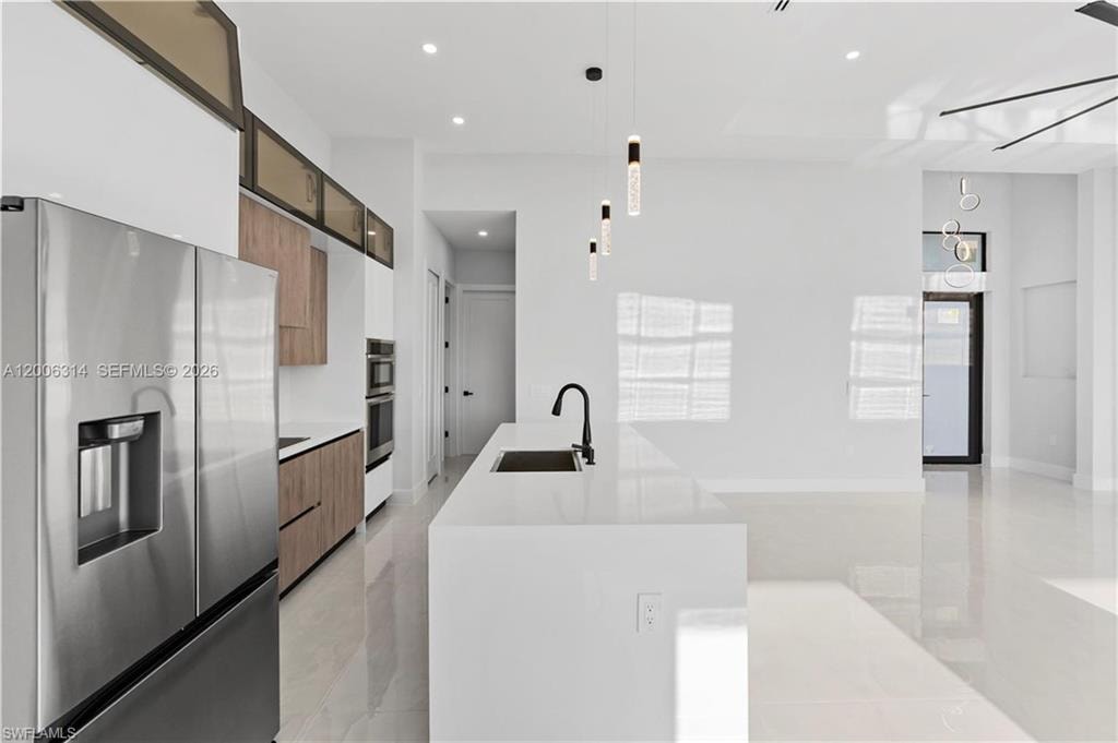Modern kitchen featuring a large stainless steel refrigerator and built-in double ovens