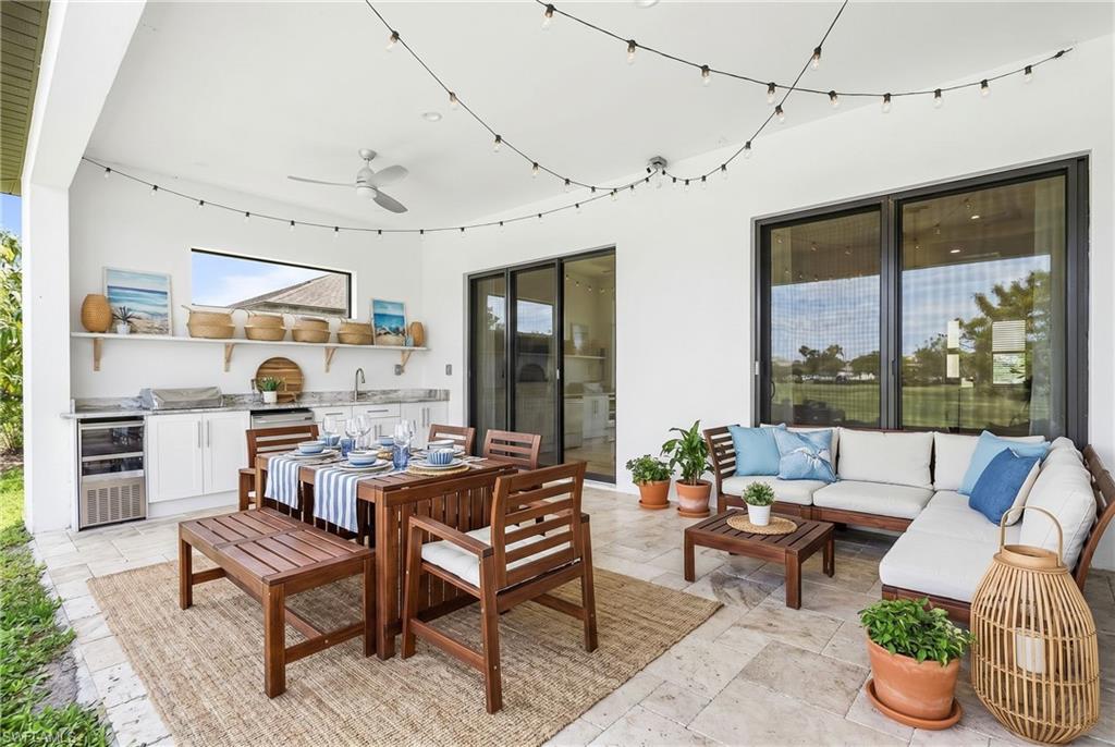 Covered patio featuring an outdoor kitchen with built-in cabinetry, an integrated sink, and a beverage refrigerator