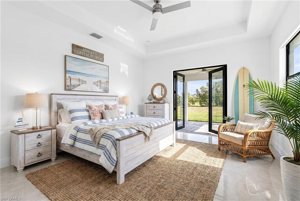White walls with a tray ceiling and a ceiling fan