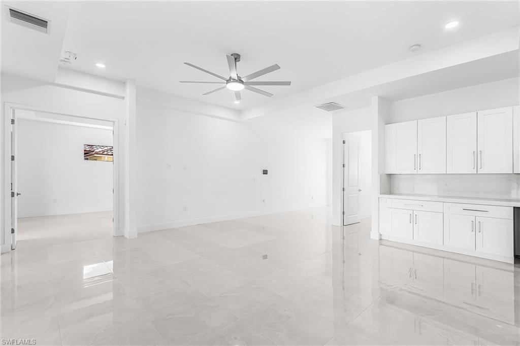 Open-concept living area featuring large format tile flooring and a contemporary ceiling fan