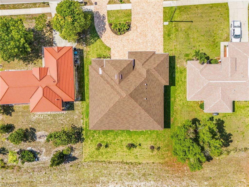 Central property with a multi-gabled brown shingle roof and a paved driveway