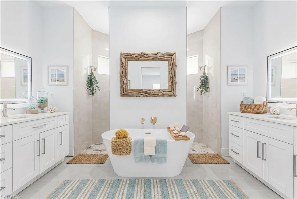 Contemporary bathroom featuring a freestanding soaking tub, dual walk-in showers with glass enclosures, and twin vanity cabinets with integrated sinks and illuminated mirrors